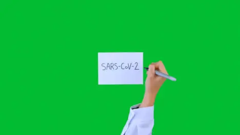 Doctor Writing SARS-Cov-2 on Paper with Green Screen