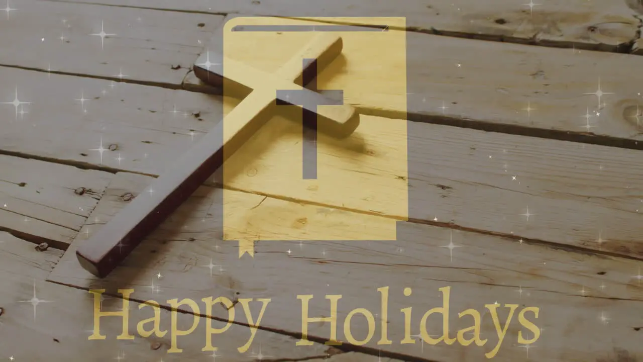 Animation of happy holidays text over christian cross on wooden background