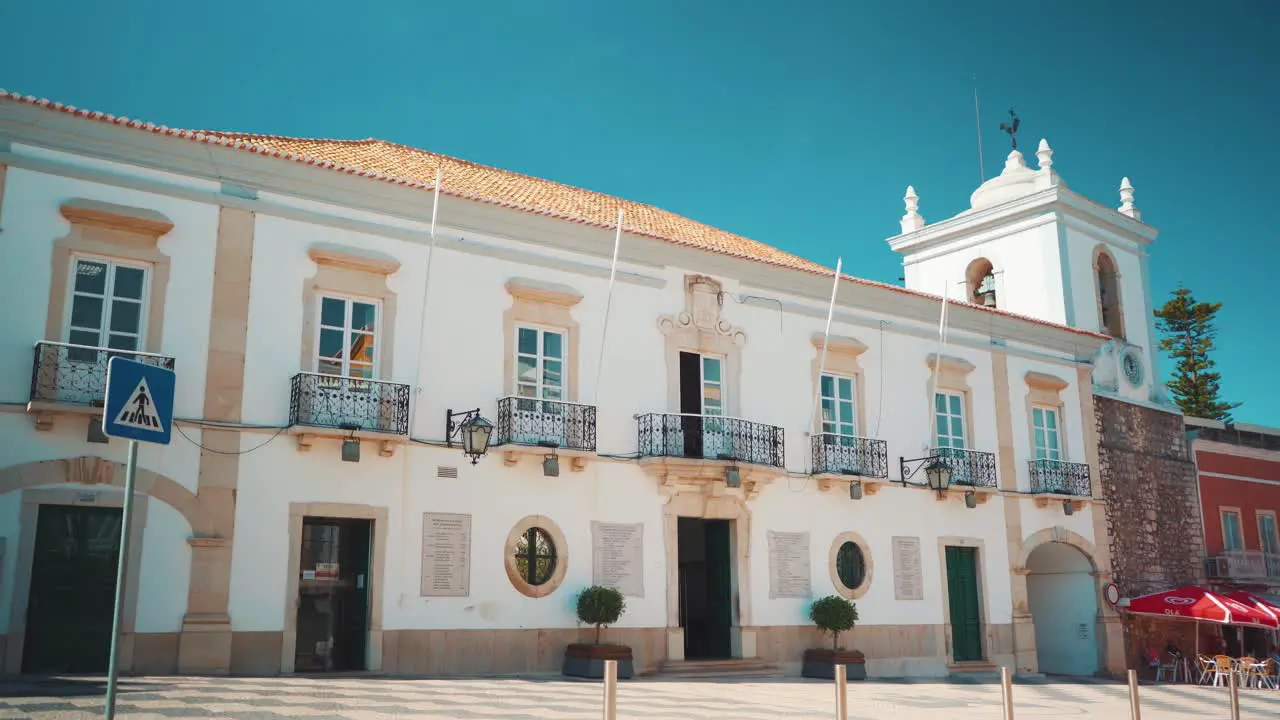 Portugal Algarve Loule typical square city hall with pedestrians cars and motorcycles passing by at morning with sunshine 4K