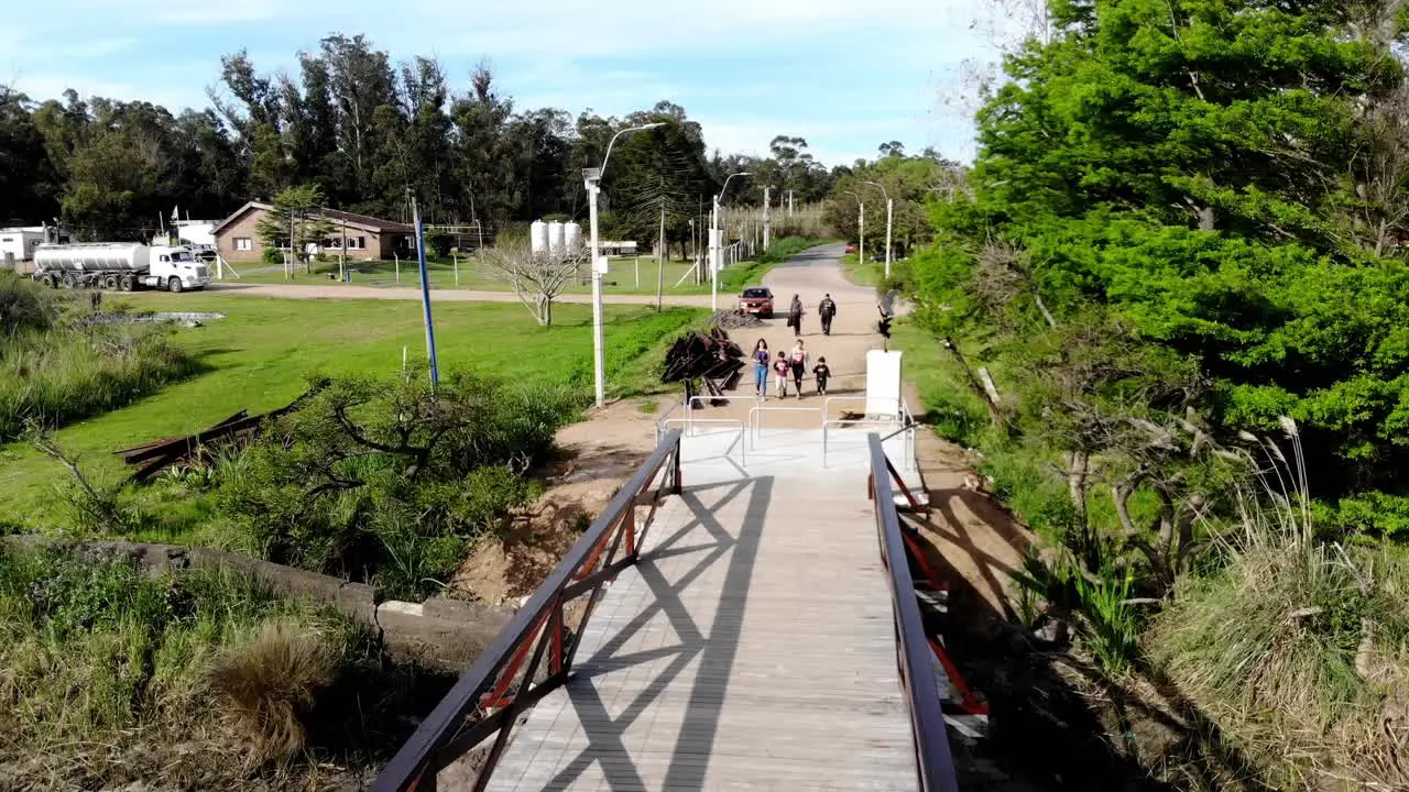 Aerial video of a family arriving at a bridge over the stream