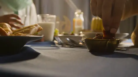 Person Eating Dates At Muslim Family Table At Home Set For Iftar Meal Breaking Daily Fast During Ramadan 2