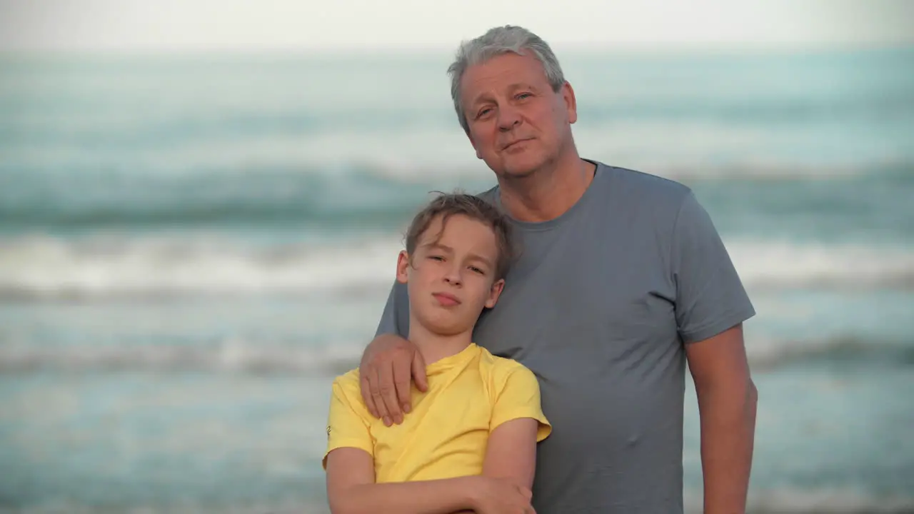 Grandpa with teenage grandchild by the ocean