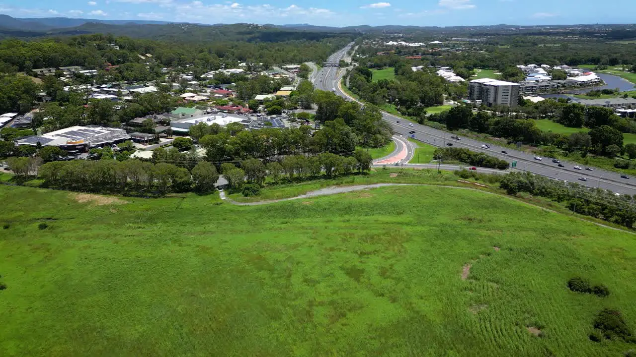 Forward moving aerial over Firth park Mudgeeraba Market Shopping centre and M1 Gold Coast Queensland Australia