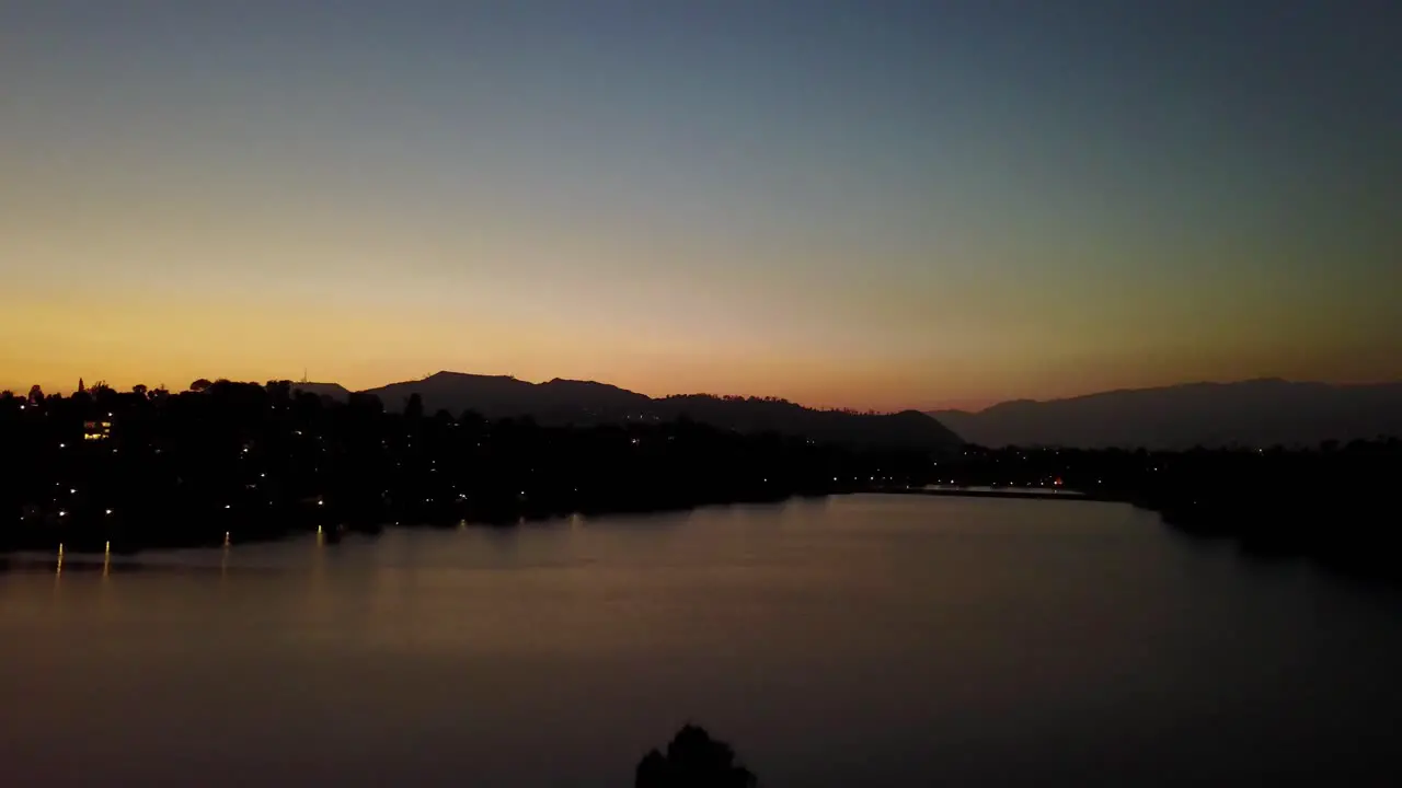 Aerial rising shot of urban lake in Los Angeles during sunset