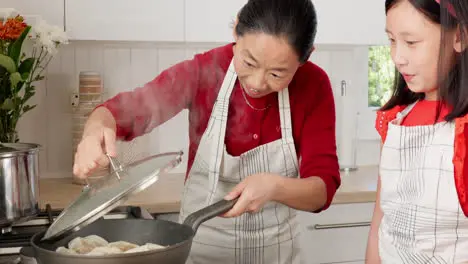 Mother girl and Asian family cooking on stove