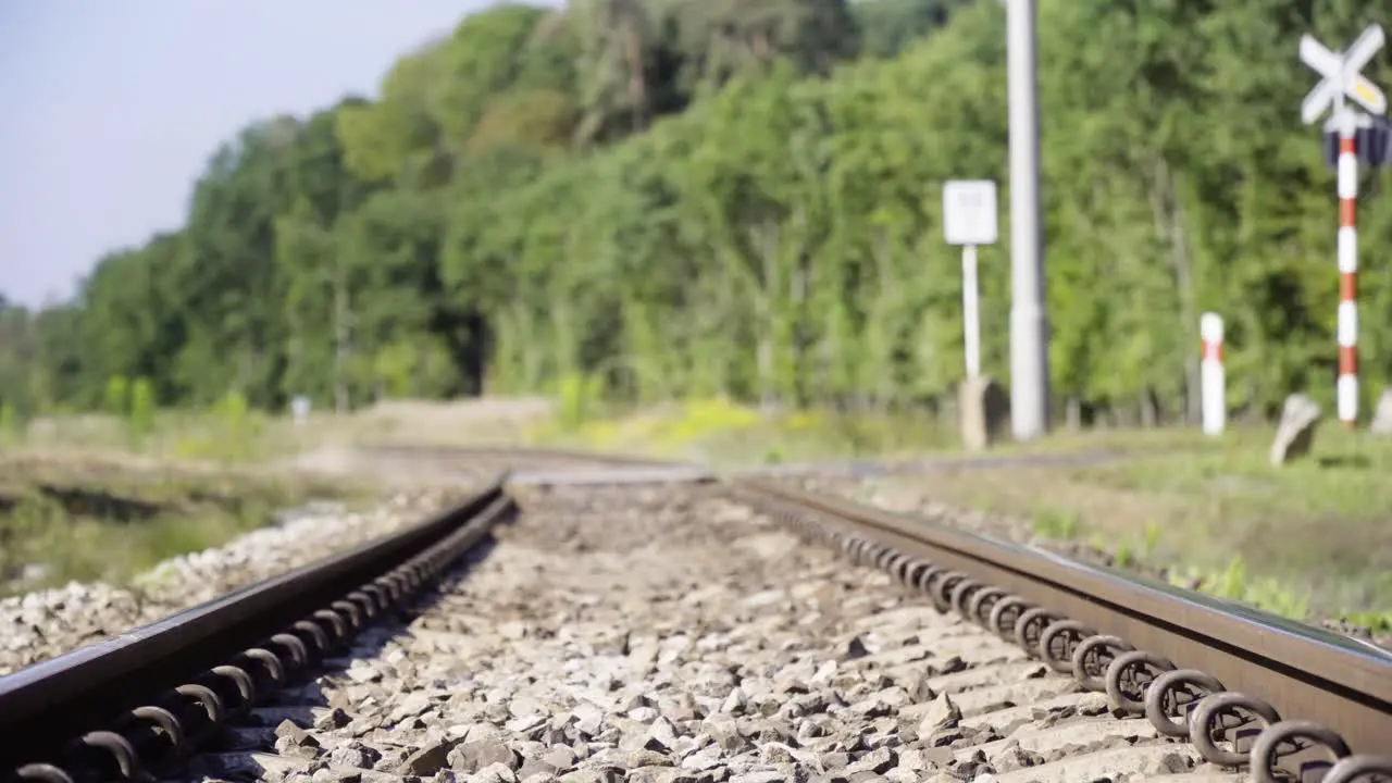 Motorcycle runs through the railway crossing in countryside in 4K