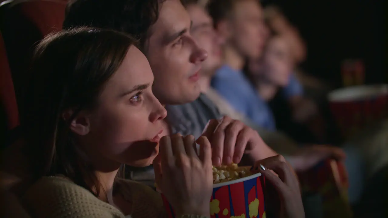 Young couple eating popcorn