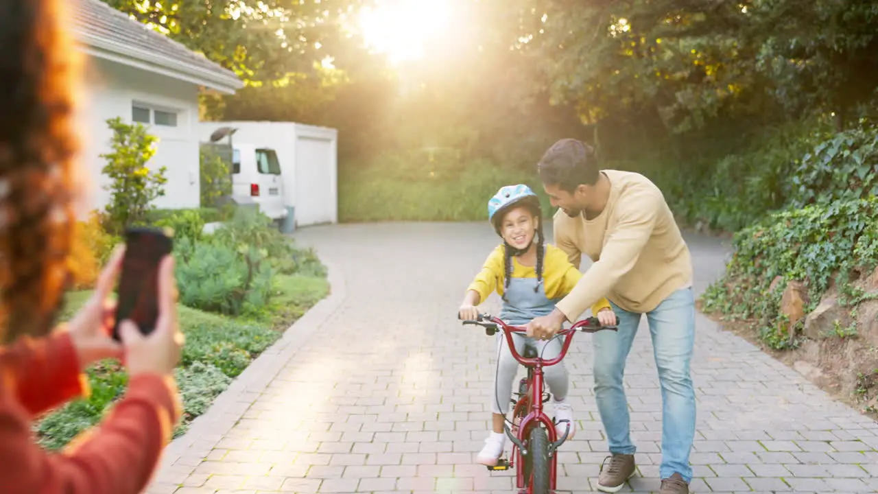 Happy family parents and teaching kid on bicycle