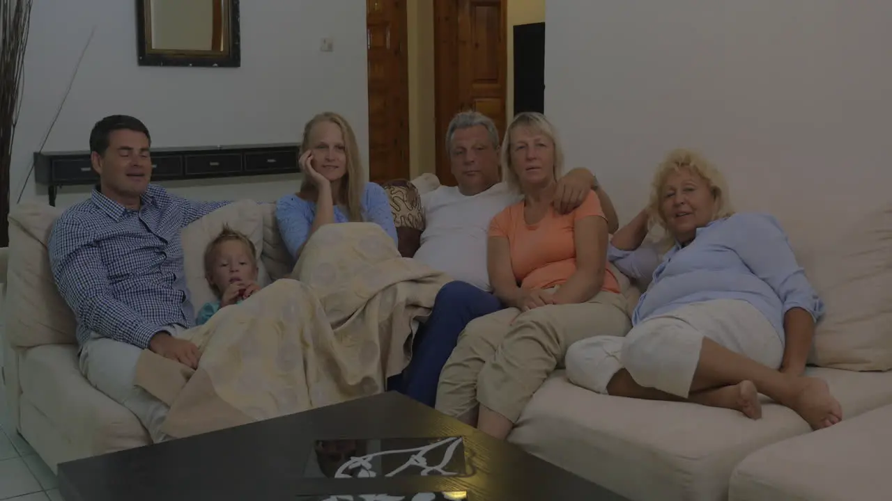 Big family watching TV in the evening