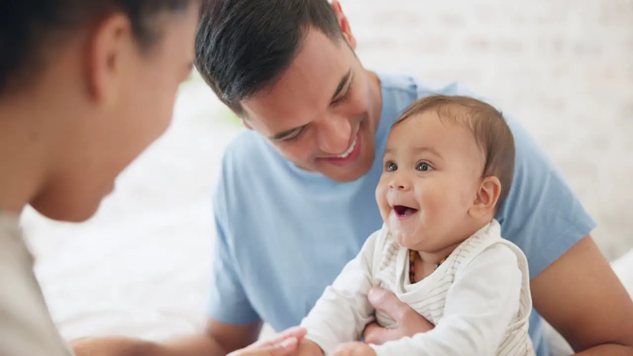 Baby playing and father with mom in bedroom