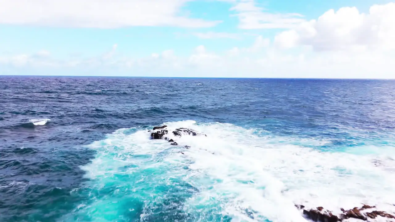 cinematic drone video of large and powerful waves crashing into the rocks during a hot summer's day on the island of hawaii whilst on a trip exploring the whole island