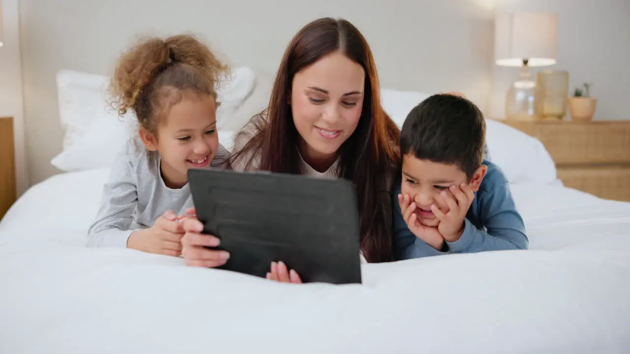 Tablet mother and children on bed with love