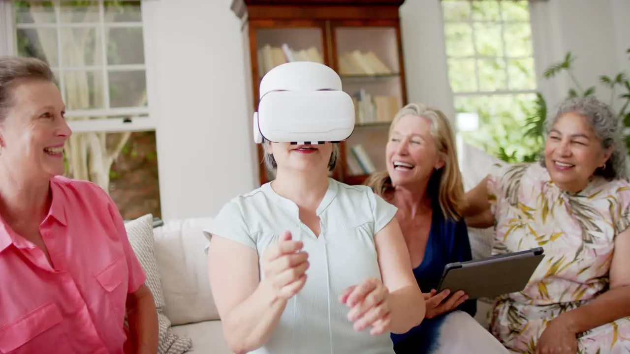 Senior diverse group of women enjoy a virtual reality experience at home