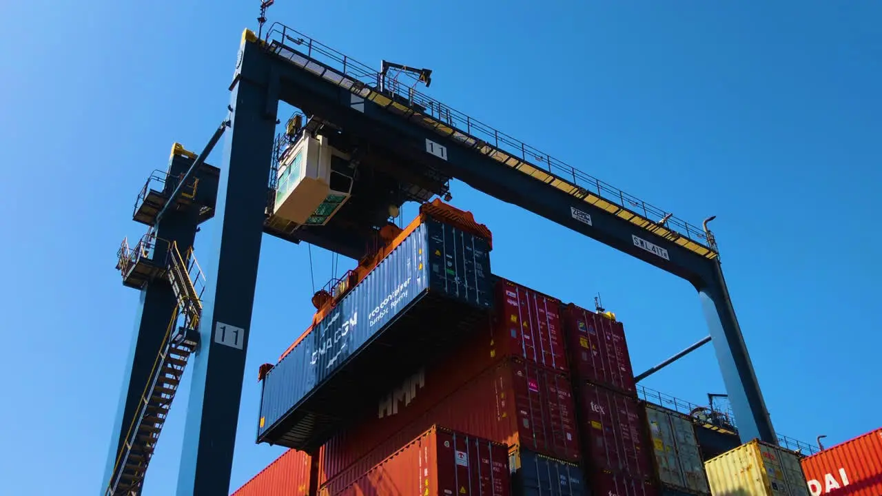 A container is being lifting up with the konecrane over the hundreds of containers at the port low angle view