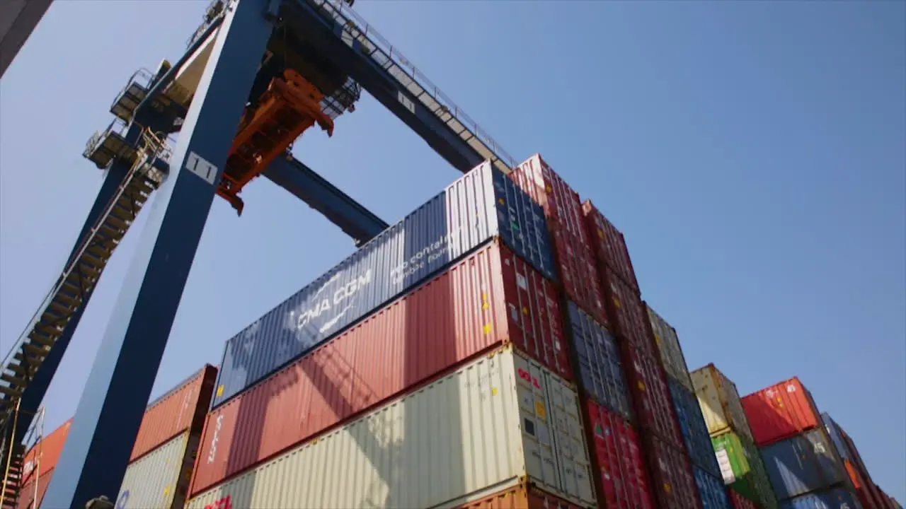 A konecrane is moving over the hundreds of containers at the port low angle view