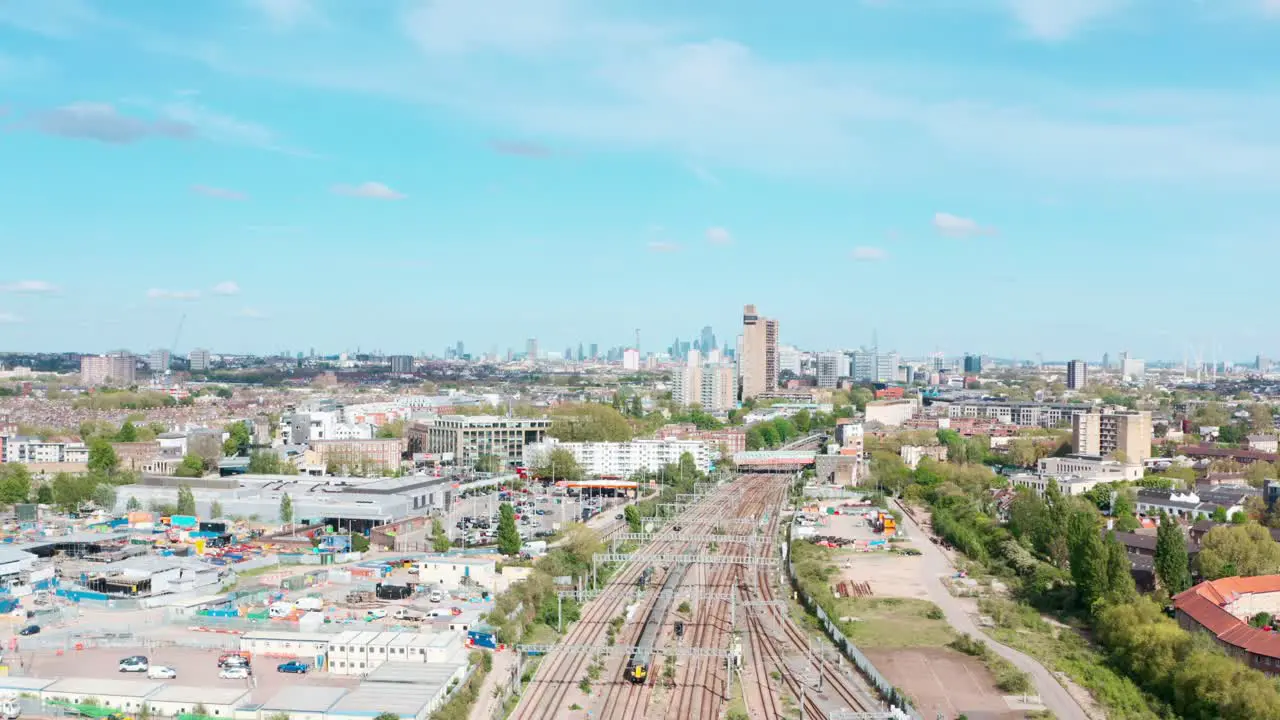 dolly back drone shot over train leaving West london