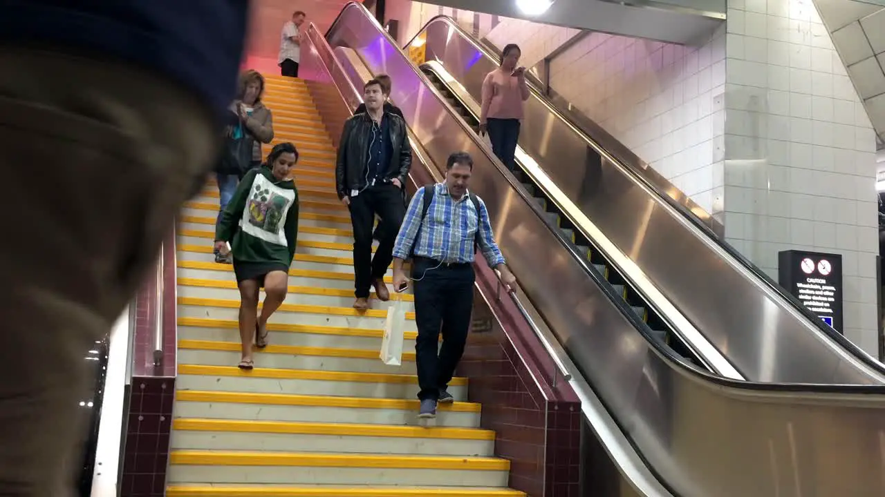 Communters arrive on the platform at Central Station down the stairs and escallators at rush hour Brisbane Australia