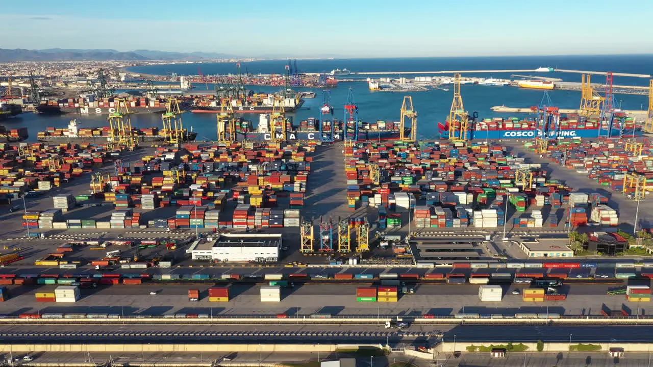 Left to right aerial traveling over Port of Valencia trucks containers Spain