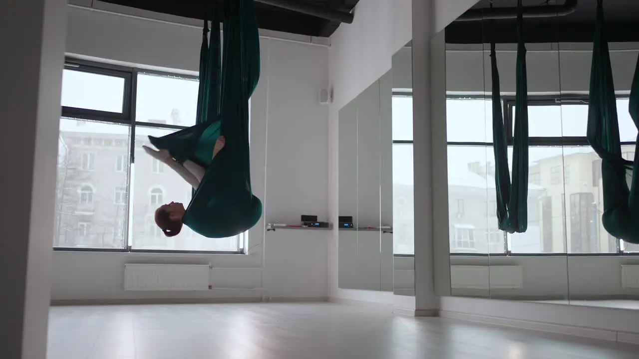 Junge Schöne Frau übt Im Aero-Stretching-Schaukel Junge Frau Rollt Ihren Kopf Kopfüber In Einer Hängematte Für Aerial Yoga Konzentrierte Ziemlich Reife Frau Die Im Fitnessstudio Luftyoga Macht