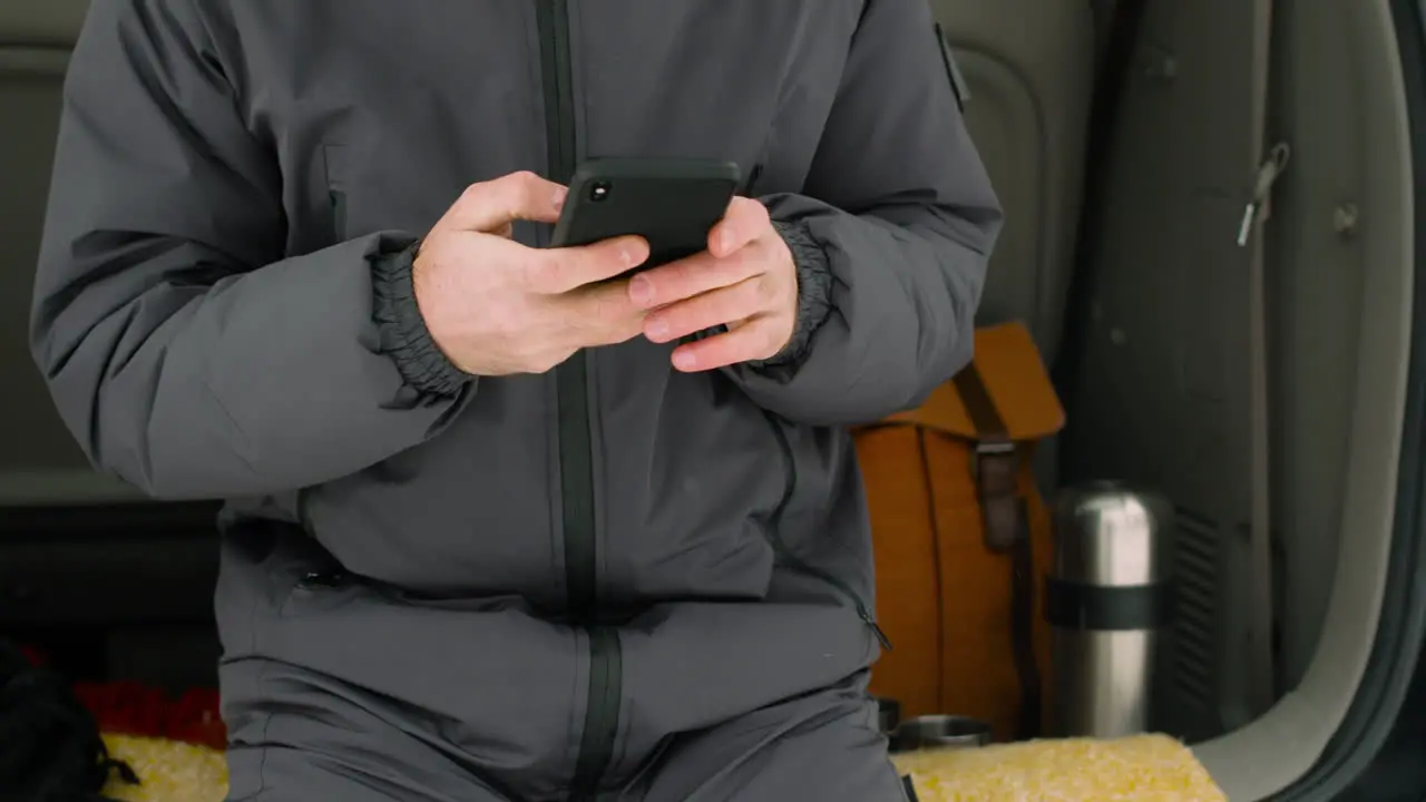 Hombre Quitándose Los Guantes Y Haciendo Una Llamada Telefónica Mientras Está Sentado En El Maletero Del Camión En Un Día De Invierno Nevado