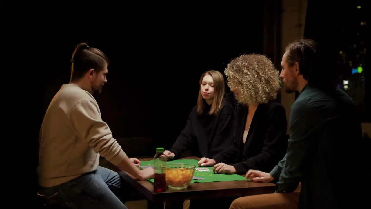 Grupo De Amigos Jugando Al Póquer Sentados En Sillas En Una Mesa En Casa 2