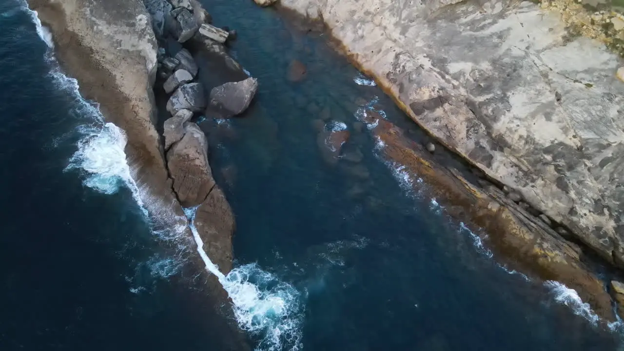 Vista Aérea De Las Olas Del Mar Salpicando En La Costa Rocosa