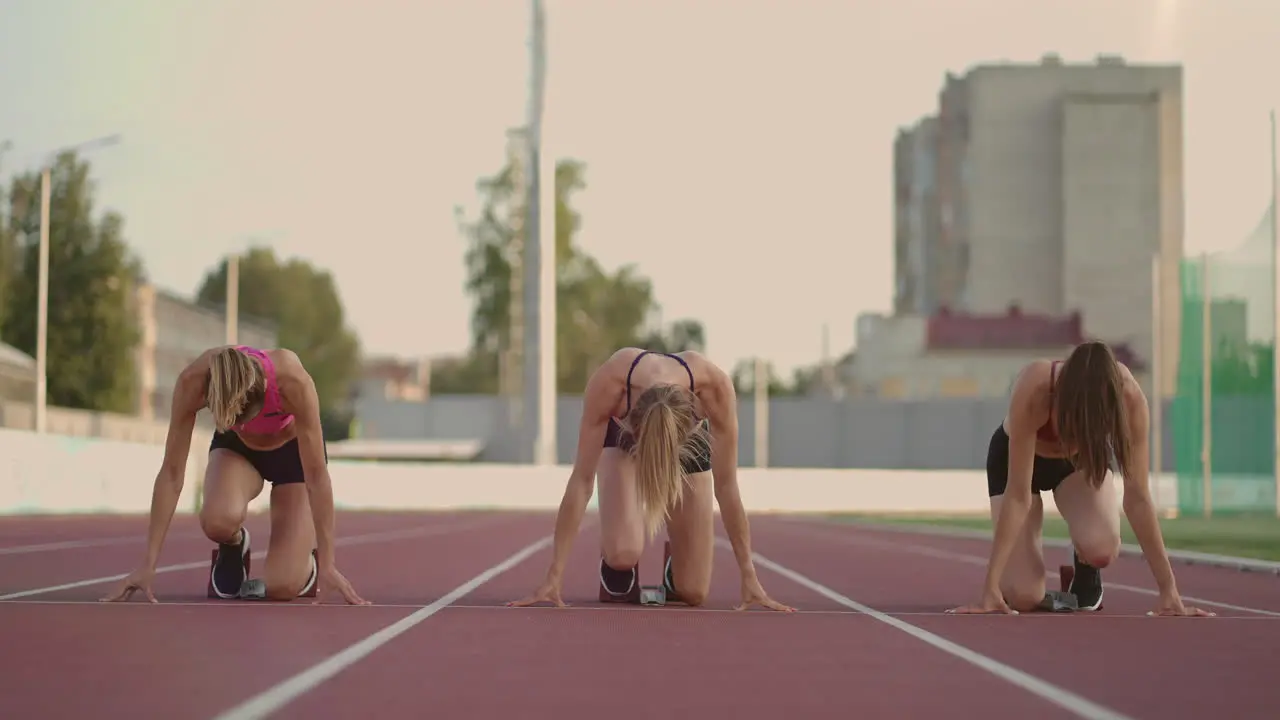 Tres Atletas Femeninas De Pista Y Agua Comienzan La Carrera En El Estadio Con Almohadillas Para Correr A Una Distancia De Sprint Mujeres Pista Y Pista Y Archivo Corredores Correr En El Estadio