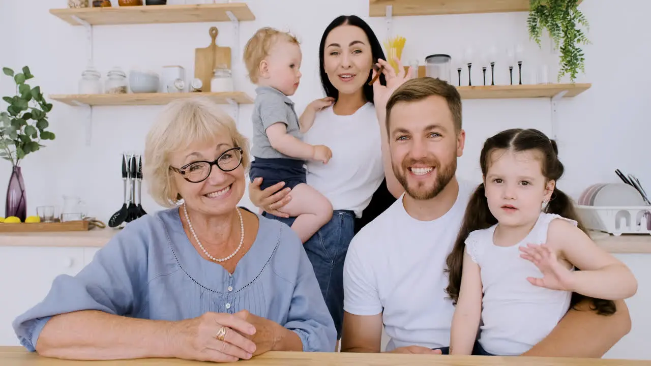 Fröhlicher Familiengruß Und Blick In Die Kamera Bei Einem Lustigen Videoanruf In Der Küche