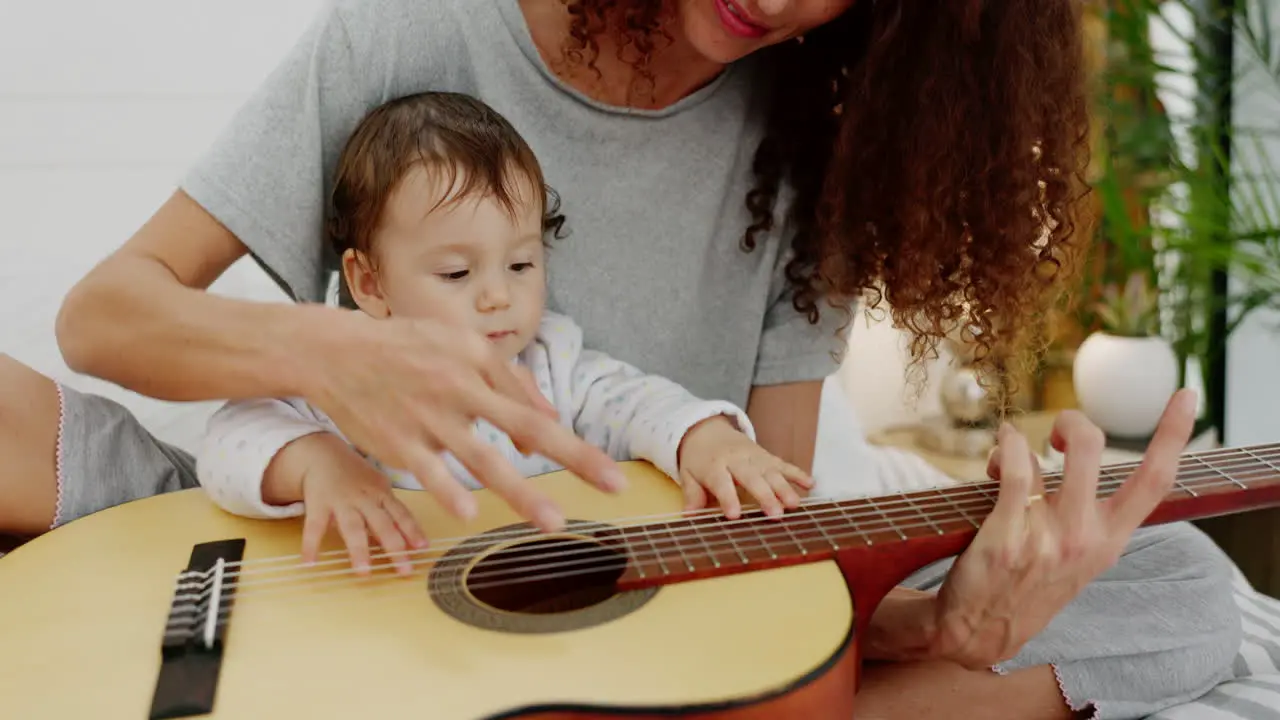 Mother and baby playing guitar for fun