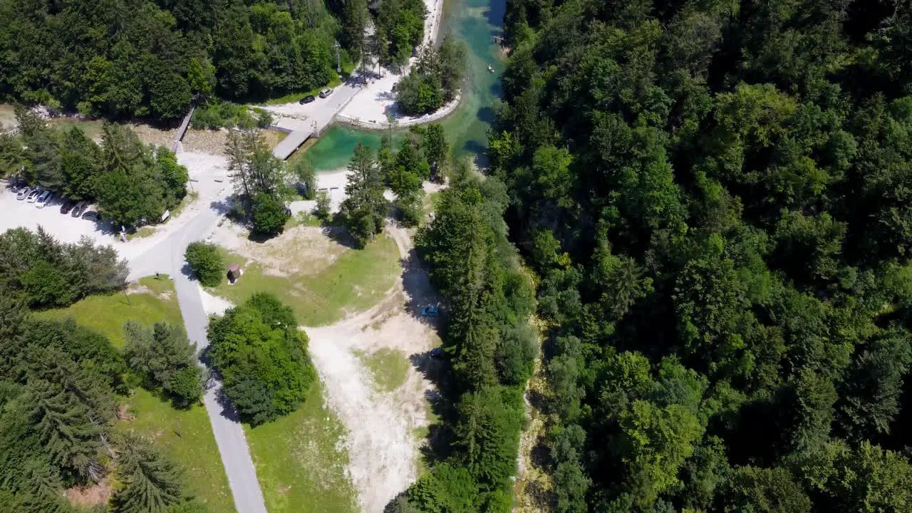 A man-made dam creates a pristine swimming spot in the lush greenery of Idrijska Bela offering an idyllic nature escape for summer fun