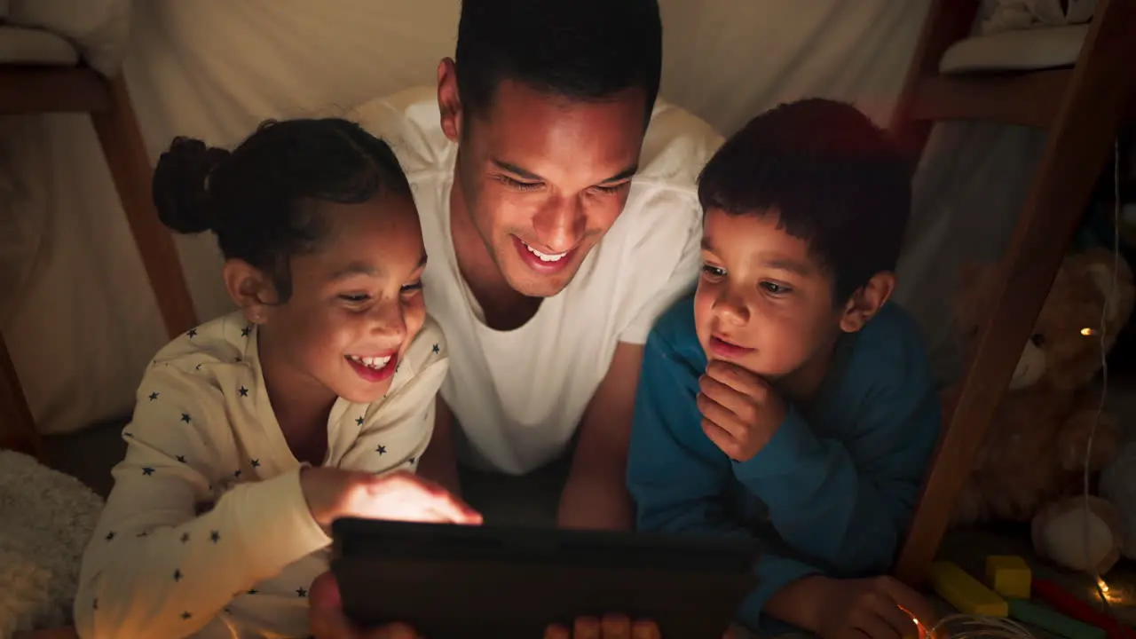 Night father and children on tablet in tent