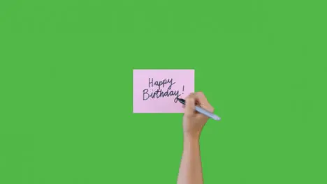 Woman Writing Happy Birthday In Cursive on Paper with Green Screen