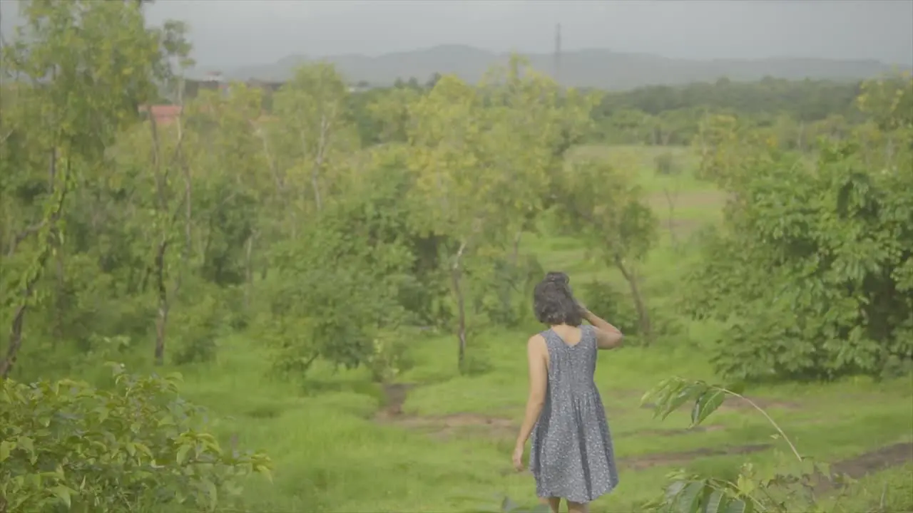 Female model walking down path through grassland