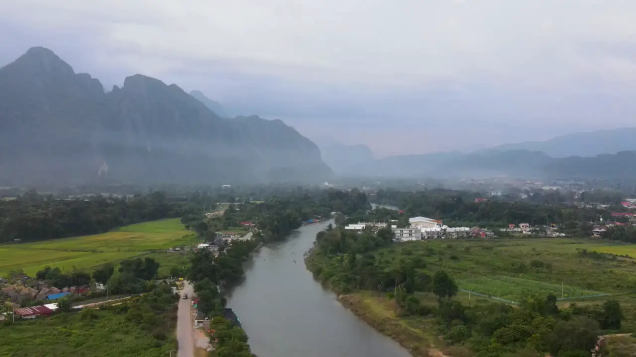 Aerial Evening View Of Vang Vieng With Nam Xong River Running Through Landscape