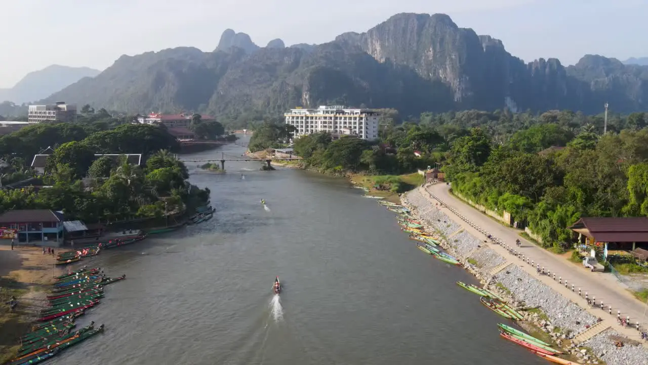 Aerial Flying over Nam Song River During Sunrise At Vang Vieng With Boats Going Past