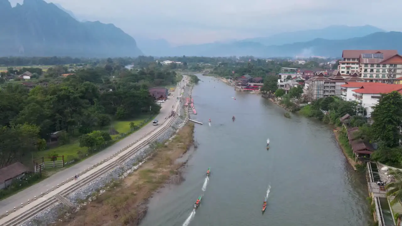 Aerial Flying over Nam Song River At Vang Vieng With Boats Going Past