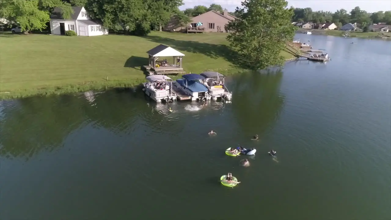 An orbiting aerial view of people swimming in a small lake