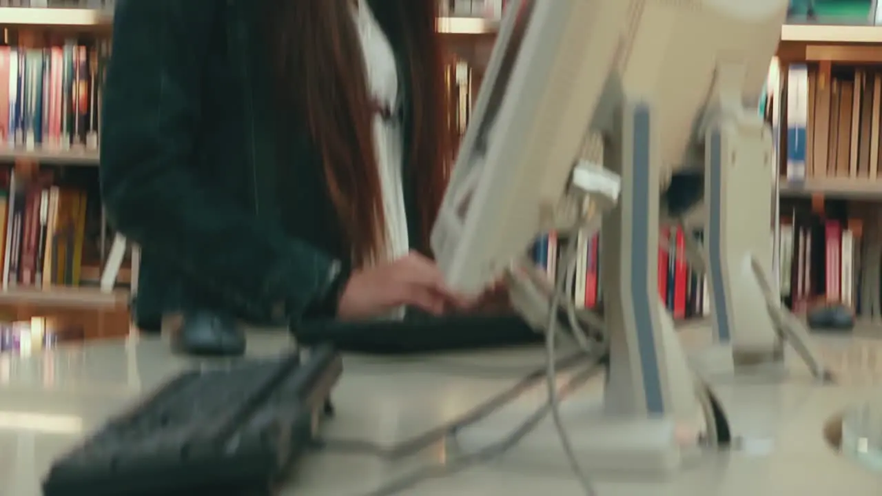 Female Asian student working at a computer station in the library