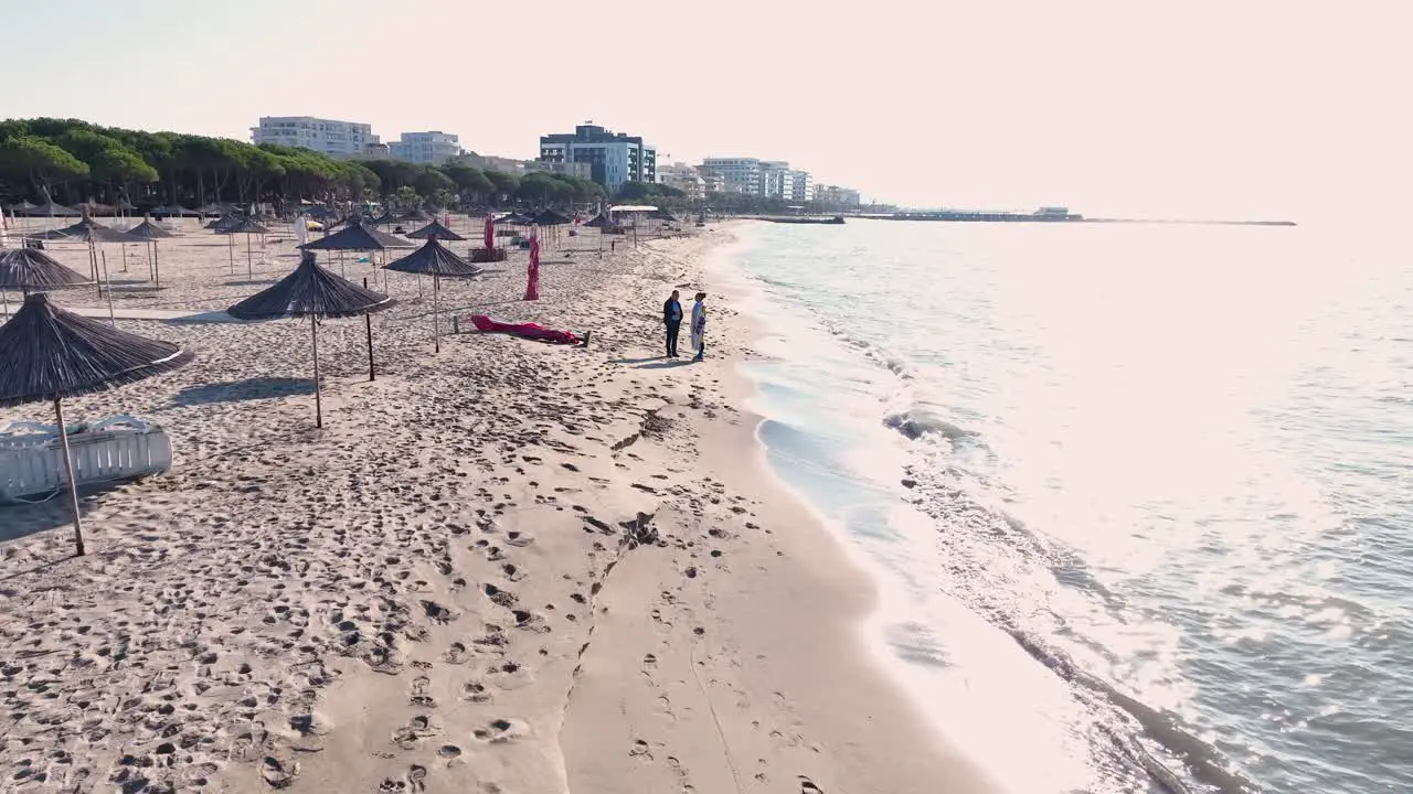 Couple walking on the beach and discussing during sunset