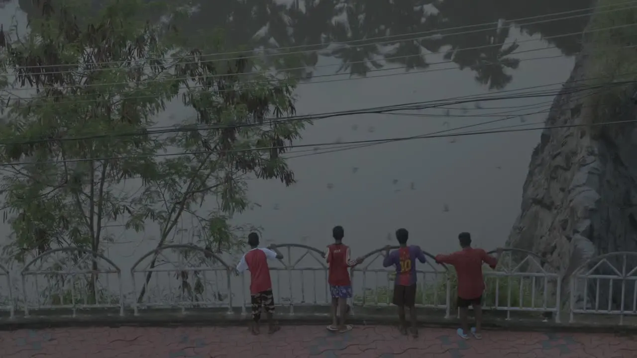 Kids in soccer uniform looking at bids and throwing stones to the lake