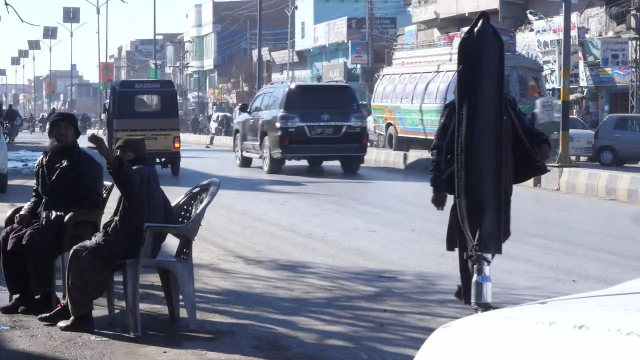 Locals Sitting On Chairs Beside Roadside As Traffic Goes By In Quetta Pakistan