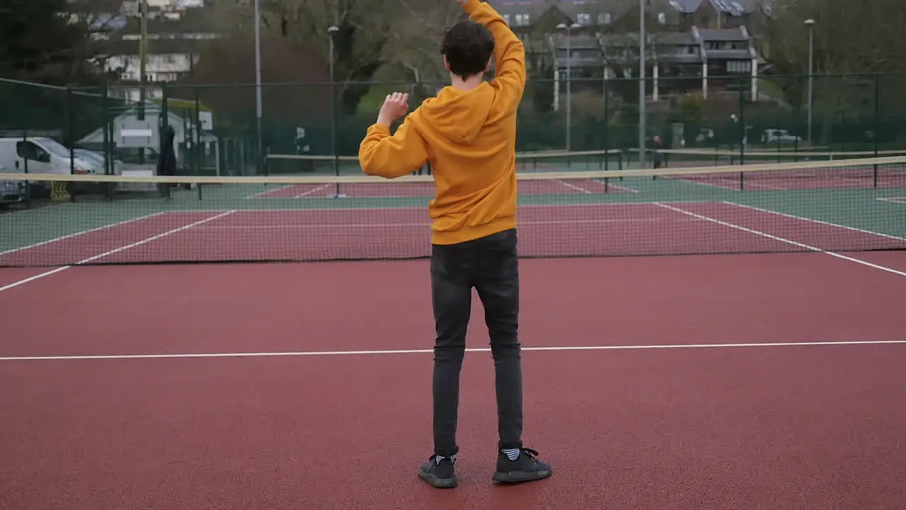 A mother and son practicing tennis in an outdoor court family time slowmo