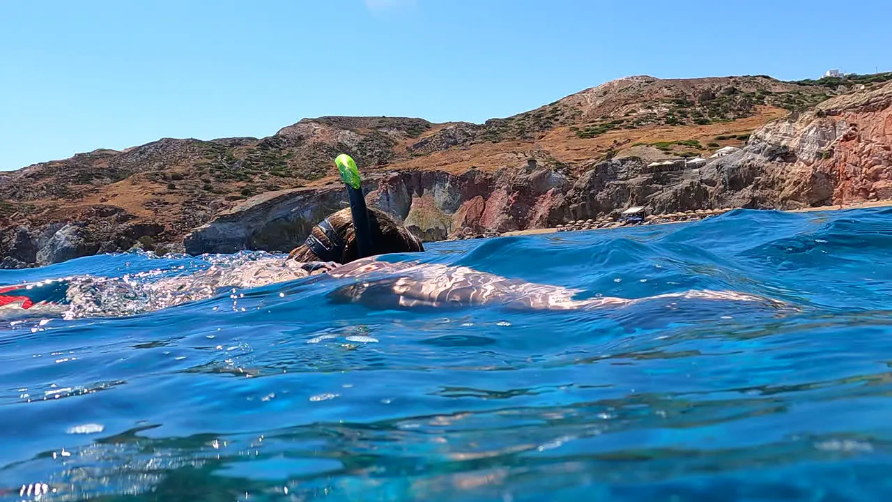 a diver swims and breathes with a snorkel