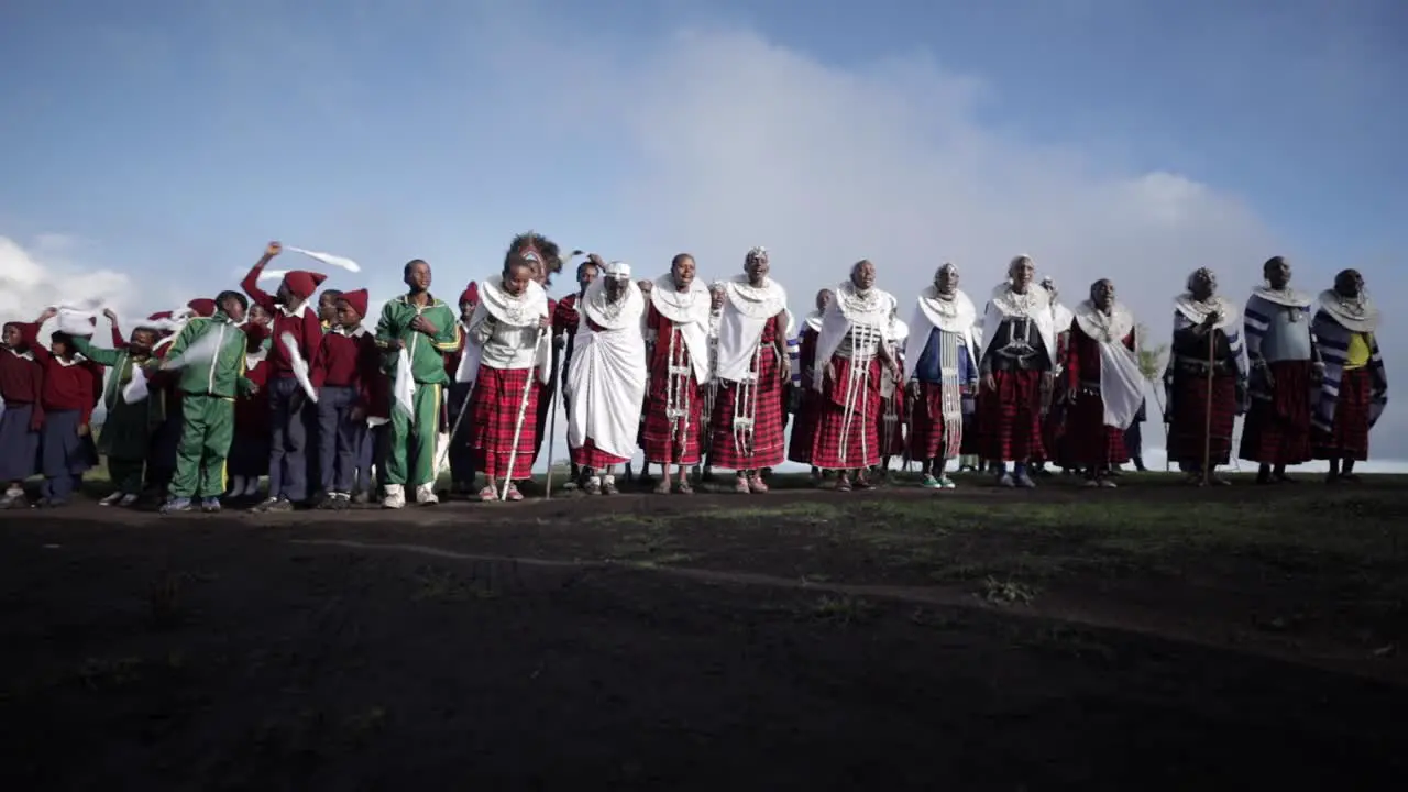 A group of villagers and school kids from the Maasai Massai Tribe are dancing and jumping for a cultural traditional ceremony in their traditional clothing in Tanzania Africa slowmotion low shot