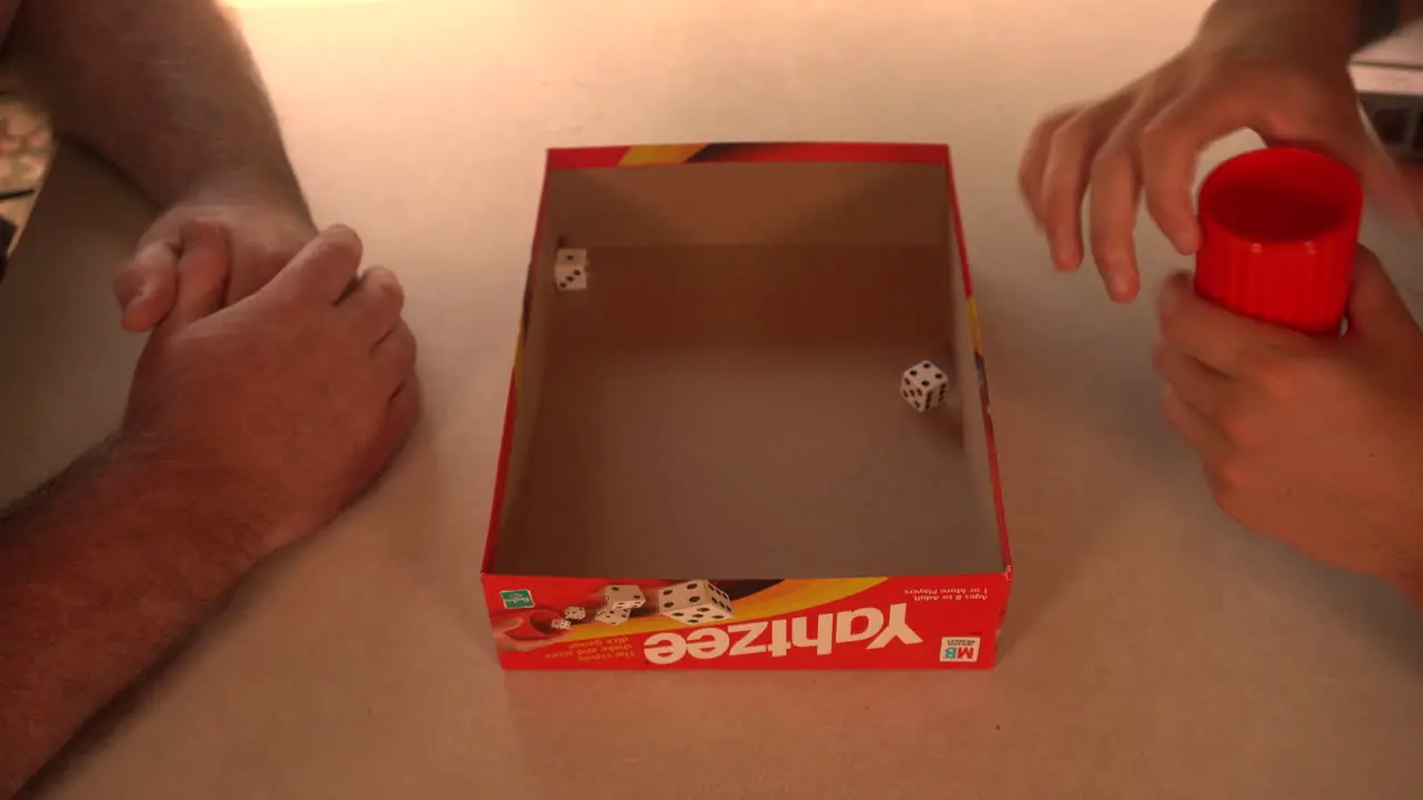 Man rolling dice on small table during game