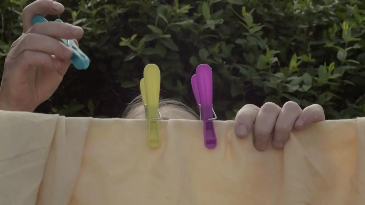 Woman hanging clothes on the washing line with pegs