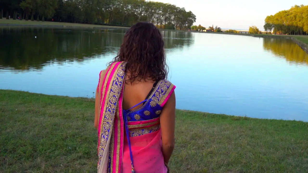 Back view of a girl walking to a lake