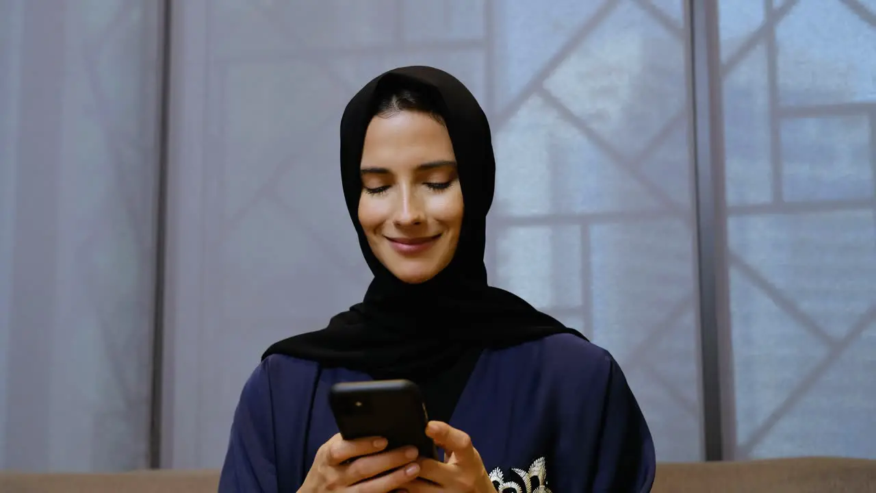 Middle East Arab girl using mobile smartphone wearing Abaya and Hijab