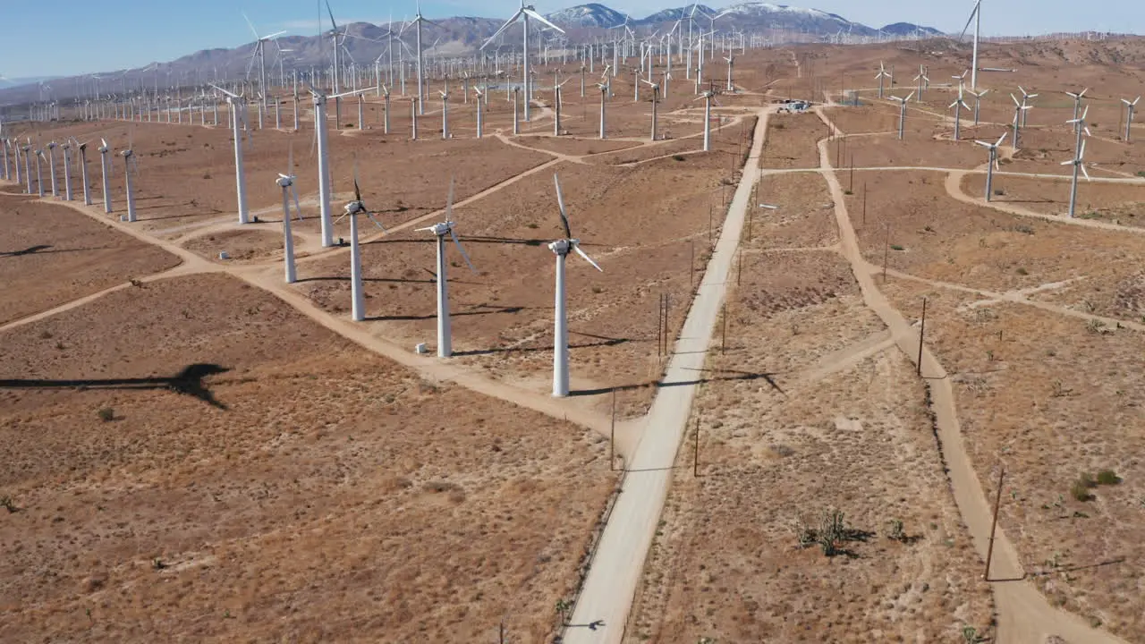 Camera moves forward and tilts up revealing a solar farm with a mountain range in the background