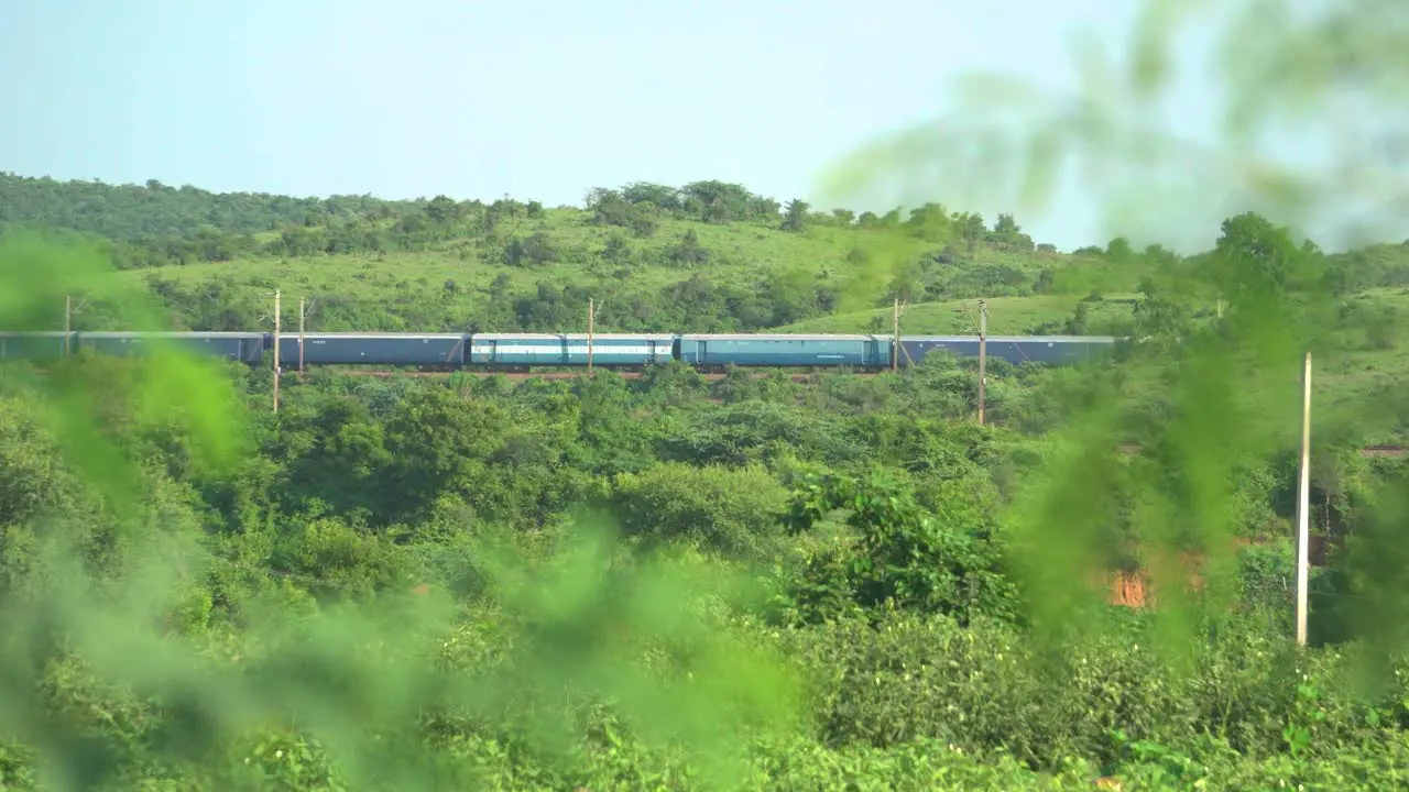 Indian railways train passing through green hills in North Central India